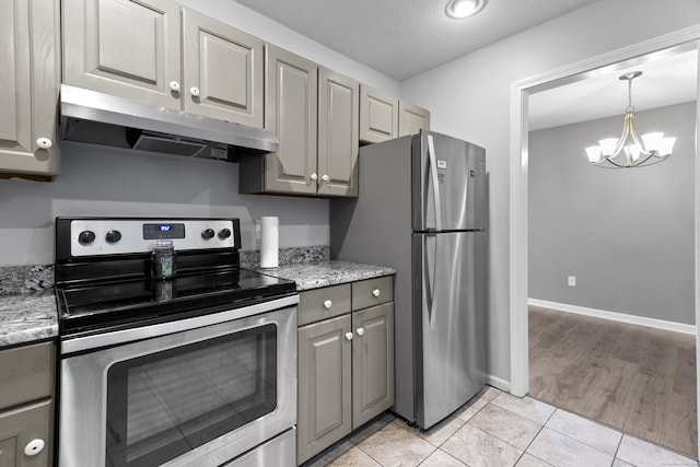601 Whetstone Mls Unit 601, Killingly, CT 06241 - kitchen featuring appliances with stainless steel finishes, under cabinet range hood, gray cabinets, a chandelier, and light stone counters