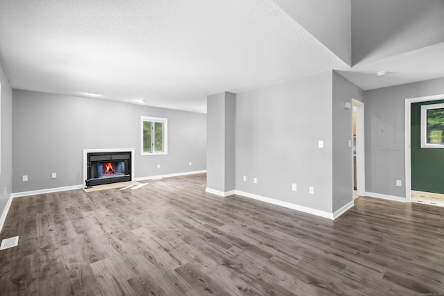 601 Whetstone Mls Unit 601, Killingly, CT 06241 - unfurnished living room featuring wood finished floors, a glass covered fireplace, baseboards, and a textured ceiling