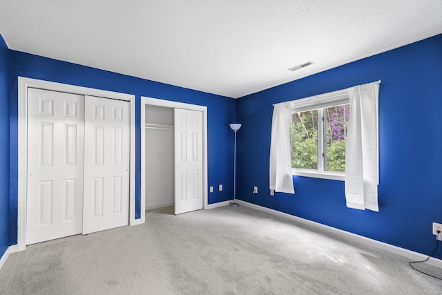 601 Whetstone Mls Unit 601, Killingly, CT 06241 - unfurnished bedroom with carpet, a textured ceiling, baseboards, and two closets
