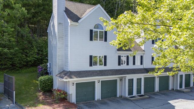 601 Whetstone Mls Unit 601, Killingly, CT 06241 - view of front of house with an attached garage, asphalt driveway, a chimney, and roof with shingles