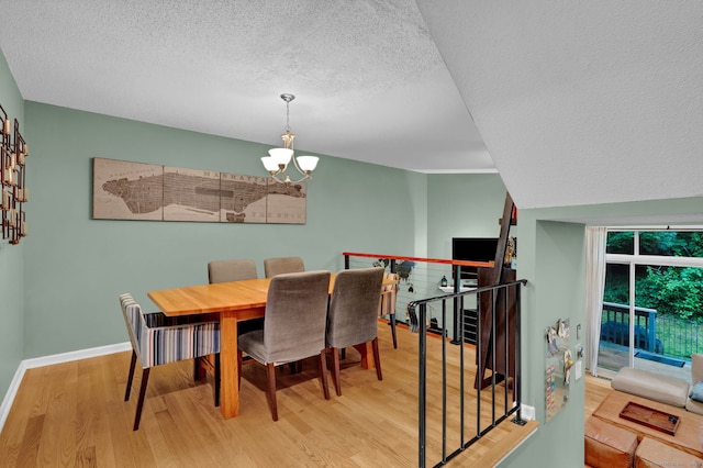 2390 State St Apt 6E, Hamden, CT 06517 - dining space featuring a textured ceiling, a chandelier, and wood finished floors