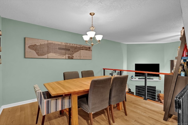 2390 State St Apt 6E, Hamden, CT 06517 - dining space featuring a chandelier, a textured ceiling, and wood finished floors