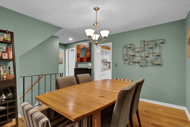 2390 State St Apt 6E, Hamden, CT 06517 - dining area featuring a chandelier, light wood-type flooring, recessed lighting, and a textured ceiling