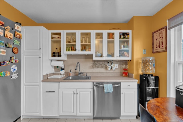2390 State St Apt 6E, Hamden, CT 06517 - kitchen with appliances with stainless steel finishes, white cabinetry, glass insert cabinets, backsplash, and light tile patterned flooring