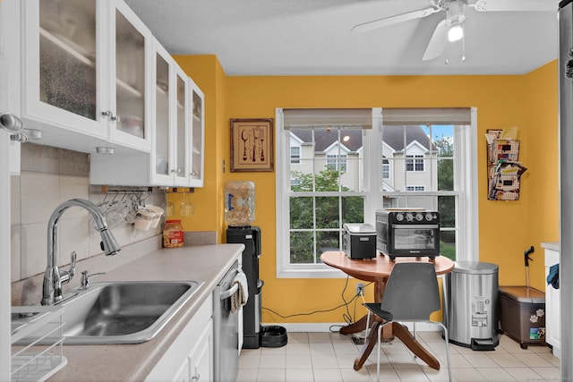 2390 State St Apt 6E, Hamden, CT 06517 - kitchen featuring light countertops, white cabinetry, ceiling fan, glass insert cabinets, and backsplash