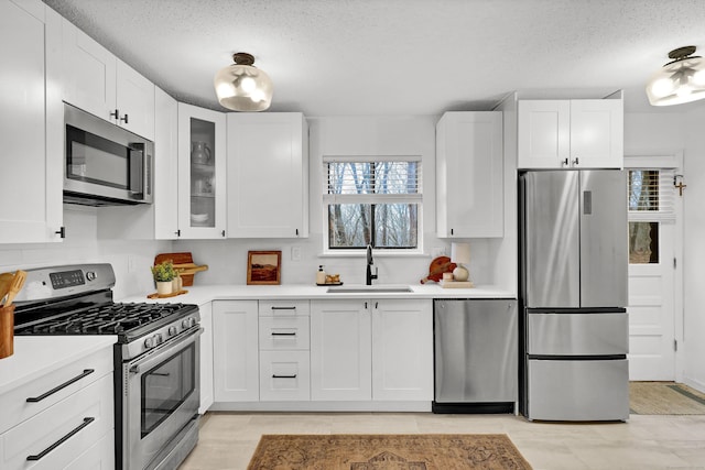124 High Path Rd Unit 124, Windsor, CT 06095 - kitchen featuring appliances with stainless steel finishes, a sink, light countertops, white cabinetry, and a textured ceiling