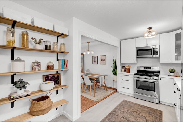124 High Path Rd Unit 124, Windsor, CT 06095 - kitchen with appliances with stainless steel finishes, white cabinetry, light countertops, decorative backsplash, and glass insert cabinets