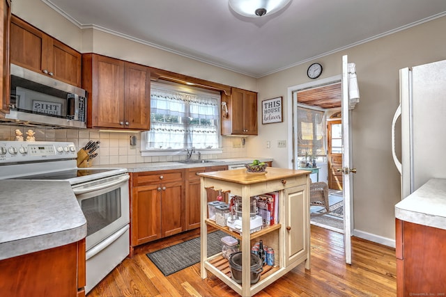 84 Kenwood Ave, Stratford, CT 06614 - kitchen featuring white range with electric cooktop, stainless steel microwave, light countertops, light wood-type flooring, and tasteful backsplash