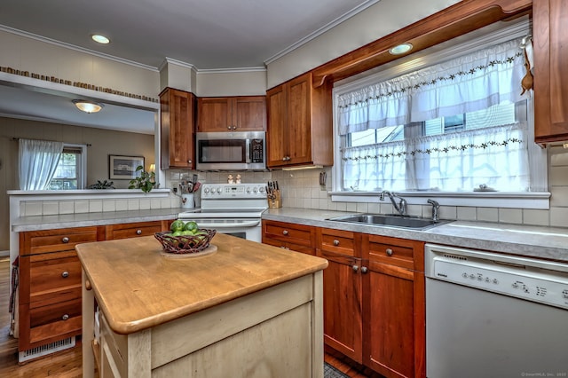 84 Kenwood Ave, Stratford, CT 06614 - kitchen with white appliances, decorative backsplash, a kitchen island, crown molding, and wood finished floors