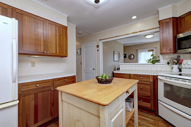84 Kenwood Ave, Stratford, CT 06614 - kitchen featuring white appliances, crown molding, wood finished floors, a kitchen island, and backsplash