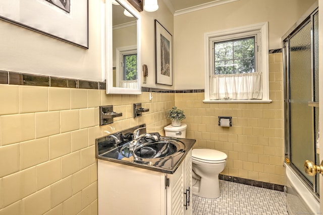 84 Kenwood Ave, Stratford, CT 06614 - bathroom featuring tile walls, vanity, crown molding, tile patterned flooring, and shower / bath combination with glass door