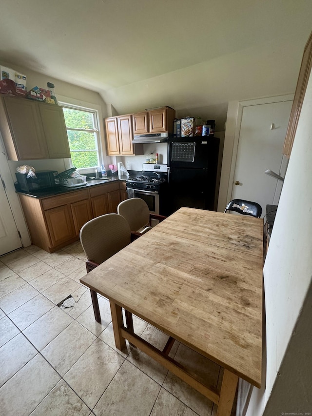28 Terrace Ave, West Haven, CT 06516 - kitchen with gas stove, under cabinet range hood, freestanding refrigerator, and light tile patterned floors