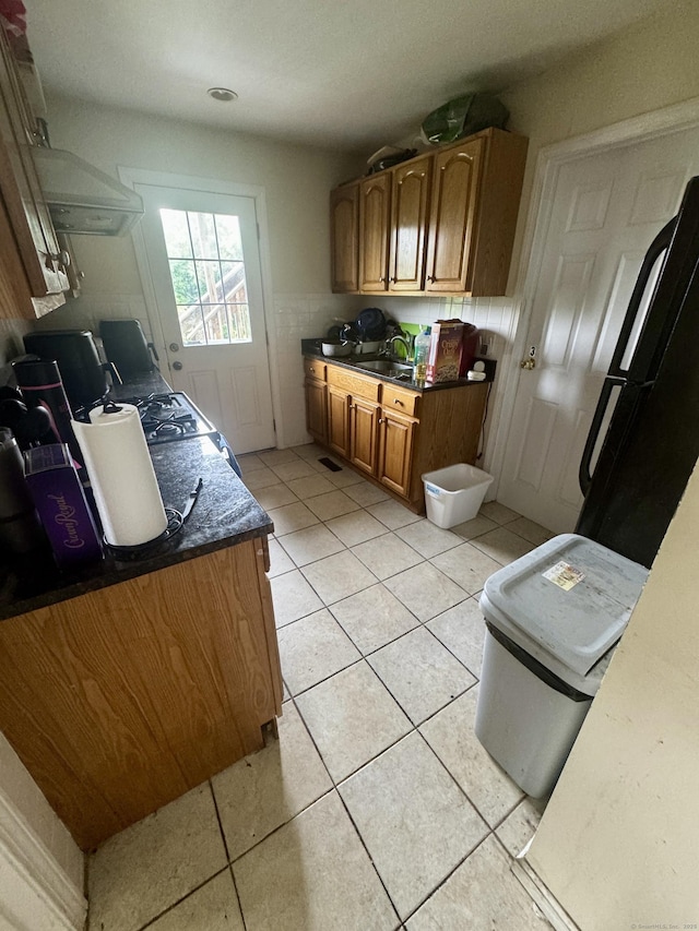 28 Terrace Ave, West Haven, CT 06516 - kitchen featuring freestanding refrigerator, light tile patterned floors, brown cabinetry, and a wainscoted wall