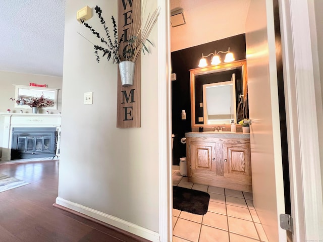 925 Oronoke Rd Unit 36G, Waterbury, CT 06708 - hall featuring a sink, a textured ceiling, baseboards, and light tile patterned floors