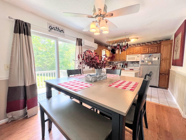925 Oronoke Rd Unit 36G, Waterbury, CT 06708 - dining room with a wall mounted AC, a ceiling fan, light wood finished floors, and a textured ceiling