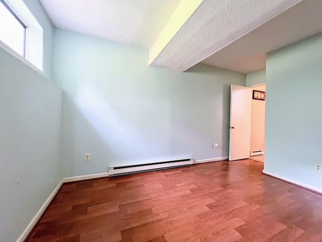925 Oronoke Rd Unit 36G, Waterbury, CT 06708 - empty room with baseboard heating, wood finished floors, a textured ceiling, a baseboard radiator, and baseboards