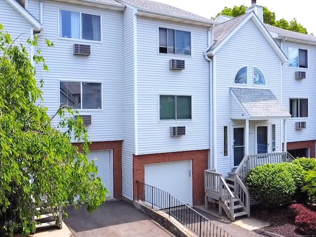 925 Oronoke Rd Unit 36G, Waterbury, CT 06708 - back of property with a garage, brick siding, an AC wall unit, and driveway