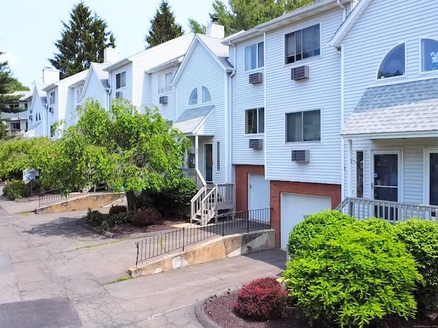 925 Oronoke Rd Unit 36G, Waterbury, CT 06708 - view of property with a garage, asphalt driveway, a wall mounted air conditioner, and a residential view