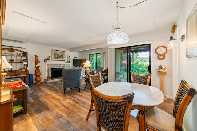 543 Heritage Vlg Unit A, Southbury, CT 06488 - dining area featuring a wall mounted AC, wood finished floors, and a fireplace with raised hearth