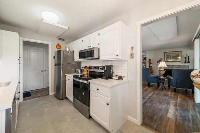 543 Heritage Vlg Unit A, Southbury, CT 06488 - kitchen with appliances with stainless steel finishes, white cabinetry, light countertops, decorative backsplash, and open floor plan