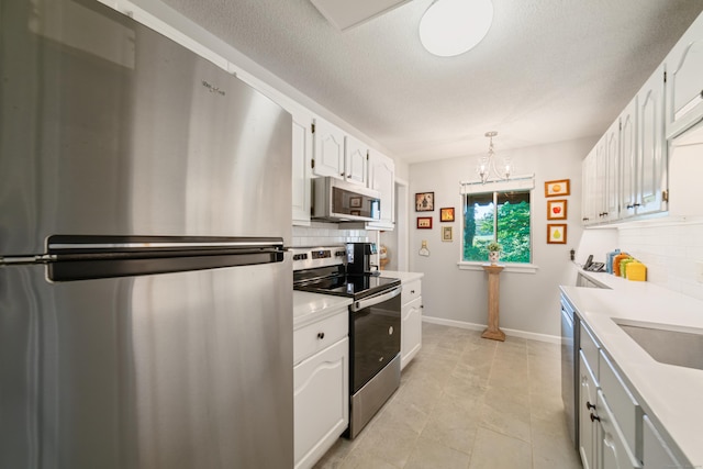 543 Heritage Vlg Unit A, Southbury, CT 06488 - kitchen with appliances with stainless steel finishes, decorative backsplash, light countertops, white cabinetry, and a textured ceiling