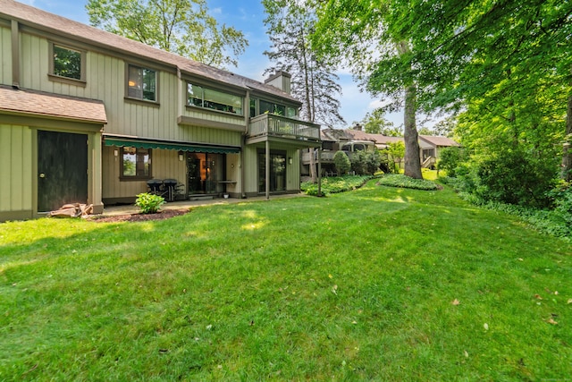 543 Heritage Vlg Unit A, Southbury, CT 06488 - back of property featuring a chimney, a lawn, roof with shingles, and a balcony
