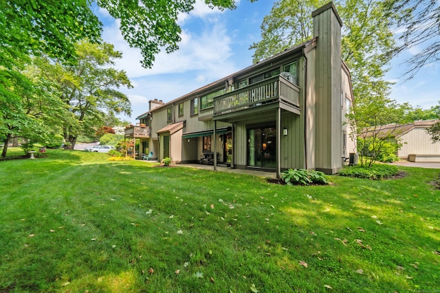 543 Heritage Vlg Unit A, Southbury, CT 06488 - rear view of property with a chimney, a lawn, and a balcony