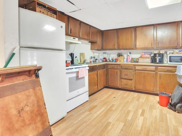 124 Main St, Sprague, CT 06330 - kitchen featuring white appliances, light wood finished floors, light countertops, under cabinet range hood, and brown cabinetry
