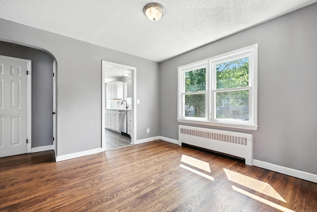 103 Anthony St, New Haven, CT 06515 - unfurnished bedroom featuring radiator heating unit, wood finished floors, arched walkways, a textured ceiling, and ensuite bath