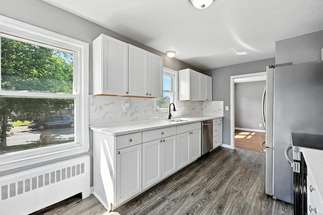 103 Anthony St, New Haven, CT 06515 - kitchen featuring radiator heating unit, stainless steel appliances, decorative backsplash, light countertops, and white cabinetry