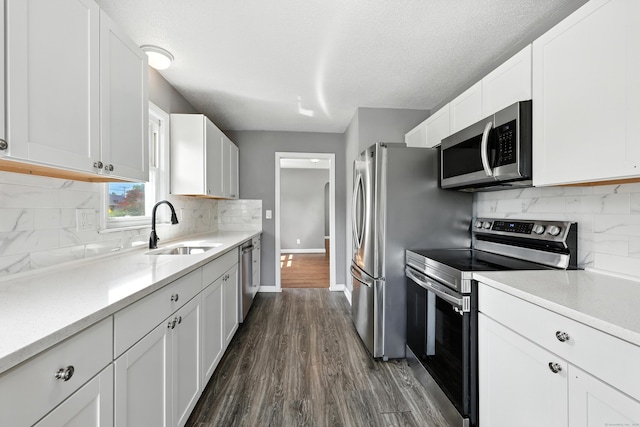 103 Anthony St, New Haven, CT 06515 - kitchen with stainless steel appliances, dark wood-style floors, tasteful backsplash, white cabinets, and a textured ceiling