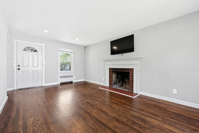 103 Anthony St, New Haven, CT 06515 - unfurnished living room featuring radiator heating unit, a brick fireplace, wood finished floors, and recessed lighting