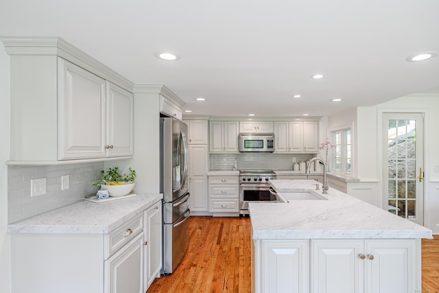 20 Copper Beech Ln, Ridgefield, CT 06877 - kitchen with appliances with stainless steel finishes, a sink, decorative backsplash, light wood finished floors, and white cabinetry