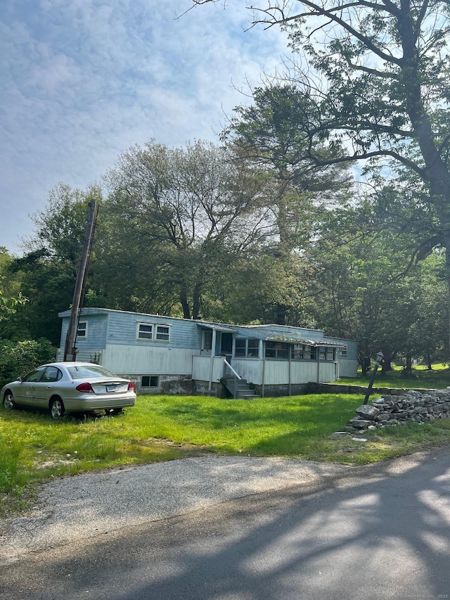 40 Tillinghast Rd, Killingly, CT 06239 - manufactured / mobile home featuring a front lawn and view of wooded area