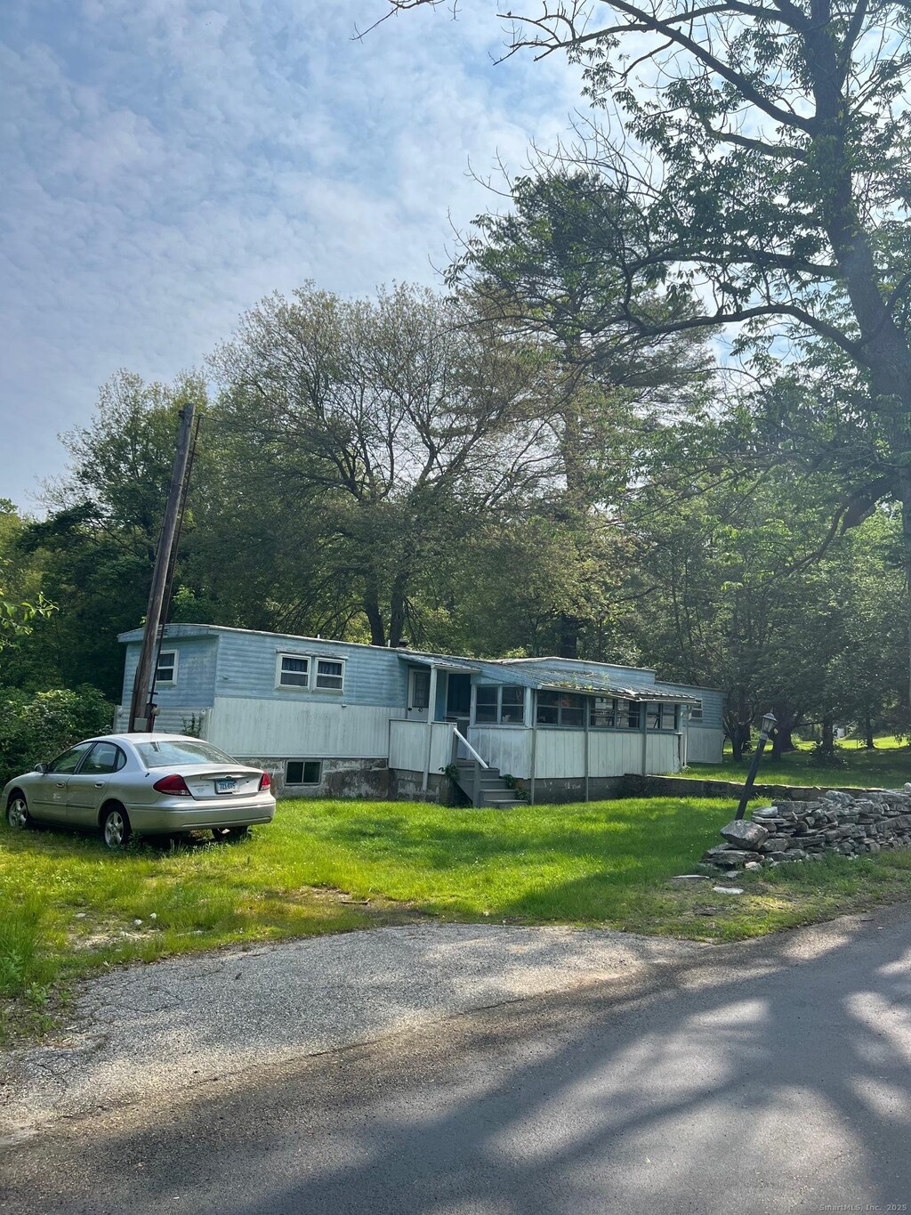 40 Tillinghast Rd, Killingly, CT 06239 - manufactured / mobile home featuring a front lawn and view of wooded area