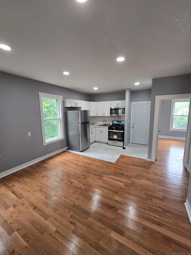 167 W St, New Haven, CT 06519 - kitchen featuring stainless steel appliances, light wood-type flooring, a sink, healthy amount of natural light, and recessed lighting