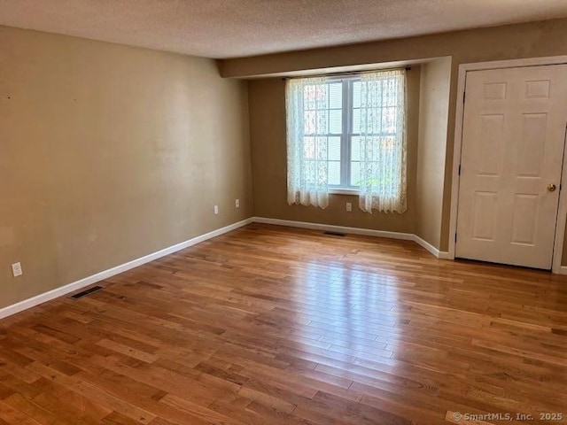 41 High St Apt 2, East Haven, CT 06512 - unfurnished room with wood finished floors, baseboards, and a textured ceiling