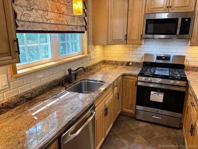 41 High St Apt 2, East Haven, CT 06512 - kitchen with stainless steel appliances, a sink, backsplash, dark stone counters, and dark tile patterned flooring