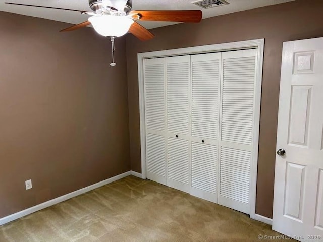 41 High St Apt 2, East Haven, CT 06512 - unfurnished bedroom featuring light carpet, a closet, baseboards, and a ceiling fan