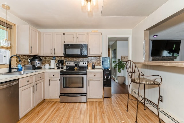128 Santa Maria Dr, Torrington, CT 06790 - kitchen featuring appliances with stainless steel finishes, a baseboard radiator, light wood-style flooring, tasteful backsplash, and light countertops