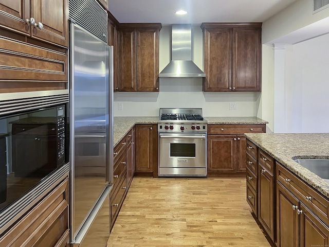 16 Hayestown Rd Unit C205, Danbury, CT 06811 - kitchen with built in appliances, wall chimney exhaust hood, light wood-style floors, light stone countertops, and recessed lighting