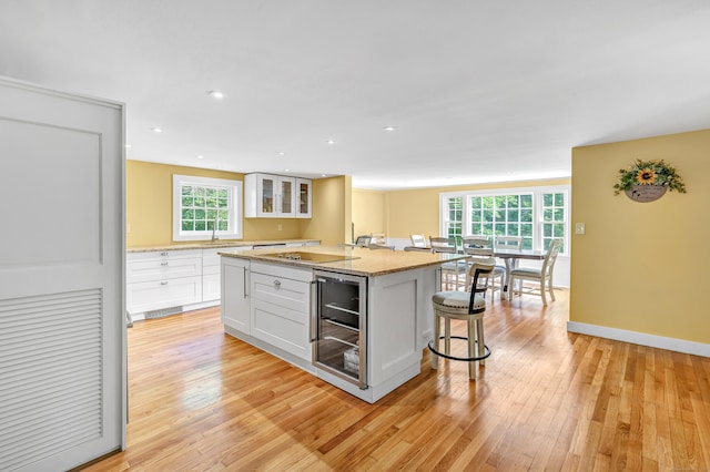 120 Huntington St, Shelton, CT 06484 - kitchen featuring a breakfast bar area, white cabinets, plenty of natural light, beverage cooler, and recessed lighting