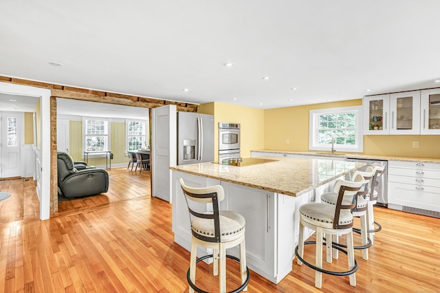 120 Huntington St, Shelton, CT 06484 - kitchen featuring appliances with stainless steel finishes, light wood finished floors, a kitchen island, white cabinetry, and recessed lighting