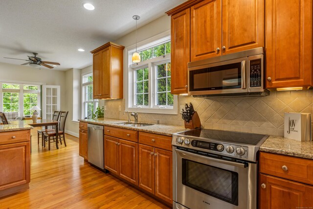 9 Benjamin Ln Unit 9, Tolland, CT 06084 - kitchen featuring appliances with stainless steel finishes, a sink, light wood-type flooring, ceiling fan, and decorative light fixtures