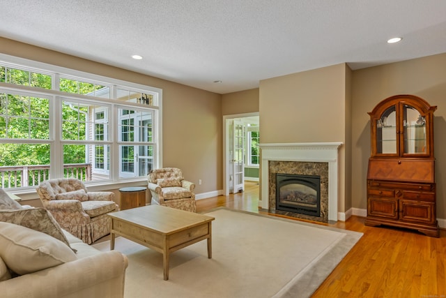 9 Benjamin Ln Unit 9, Tolland, CT 06084 - living room with a premium fireplace, a textured ceiling, light wood-style flooring, baseboards, and recessed lighting