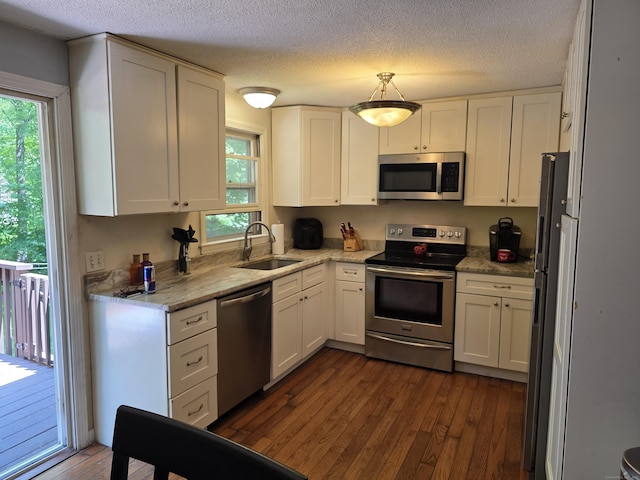 46 Richardson Hill Rd, Griswold, CT 06351 - kitchen featuring stainless steel appliances, dark wood-style flooring, healthy amount of natural light, white cabinetry, and a textured ceiling