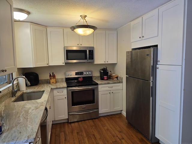 46 Richardson Hill Rd, Griswold, CT 06351 - kitchen featuring appliances with stainless steel finishes, dark wood finished floors, white cabinets, light stone counters, and a textured ceiling