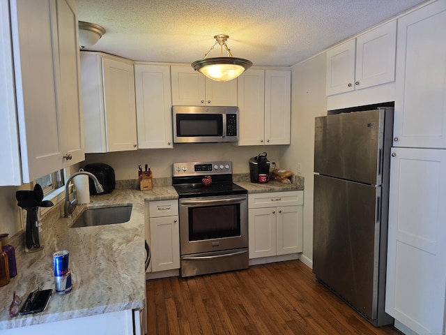 46 Richardson Hill Rd, Griswold, CT 06351 - kitchen with stainless steel appliances, dark wood-style flooring, white cabinets, light stone counters, and a textured ceiling