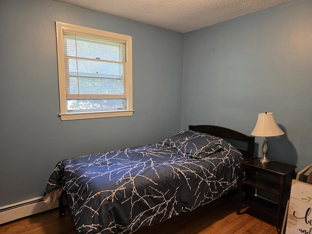 46 Richardson Hill Rd, Griswold, CT 06351 - bedroom with a baseboard heating unit, wood finished floors, and a textured ceiling
