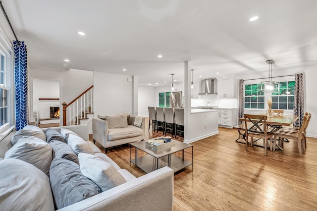 6 Buckboard Ln, Fairfield, CT 06824 - living area with light wood-style floors, healthy amount of natural light, recessed lighting, stairs, and a fireplace
